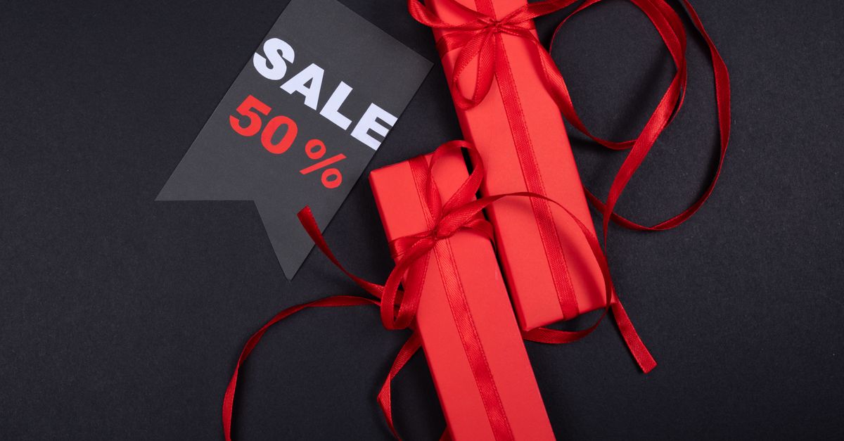 Red gift boxes with ribbons and a prominent 50% sale sign on black background.